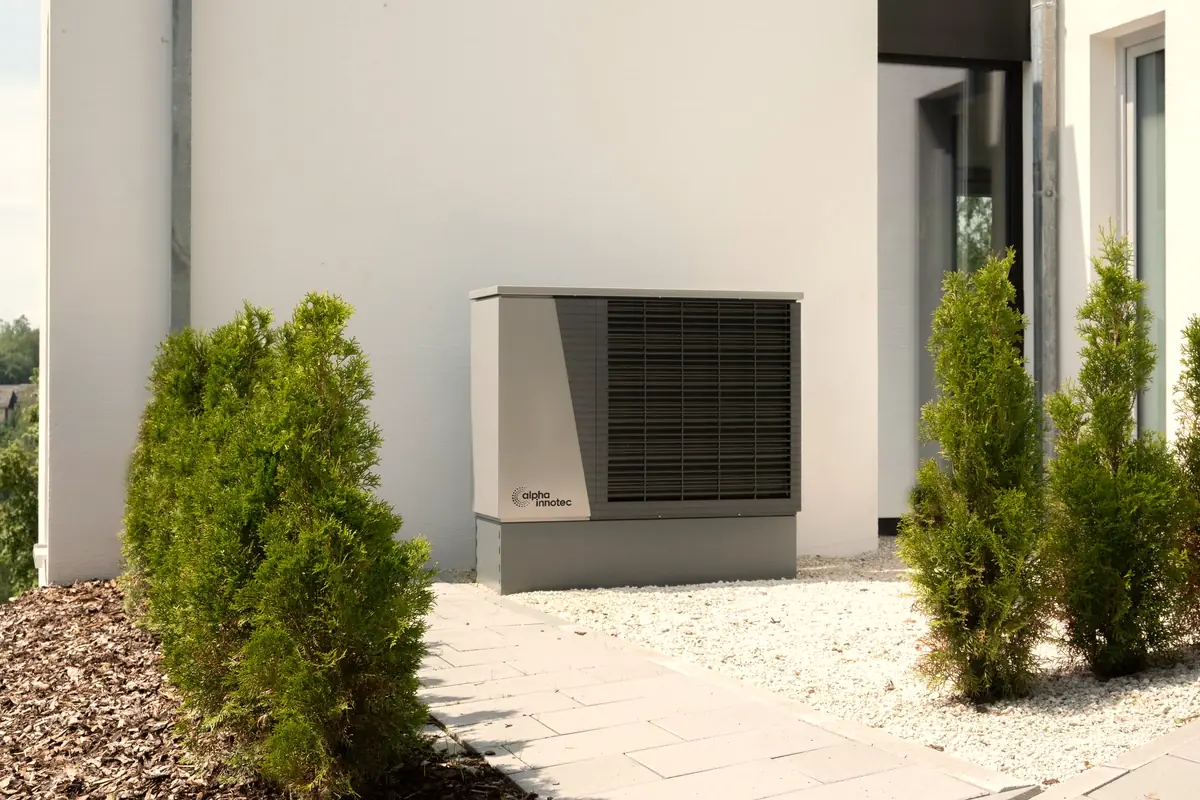 Outdoor heat pump unit beside a house