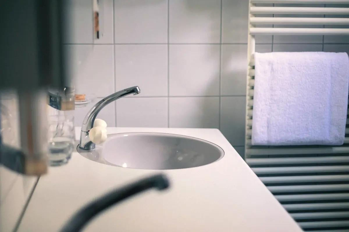 Clean bathroom sink with a modern faucet and towel