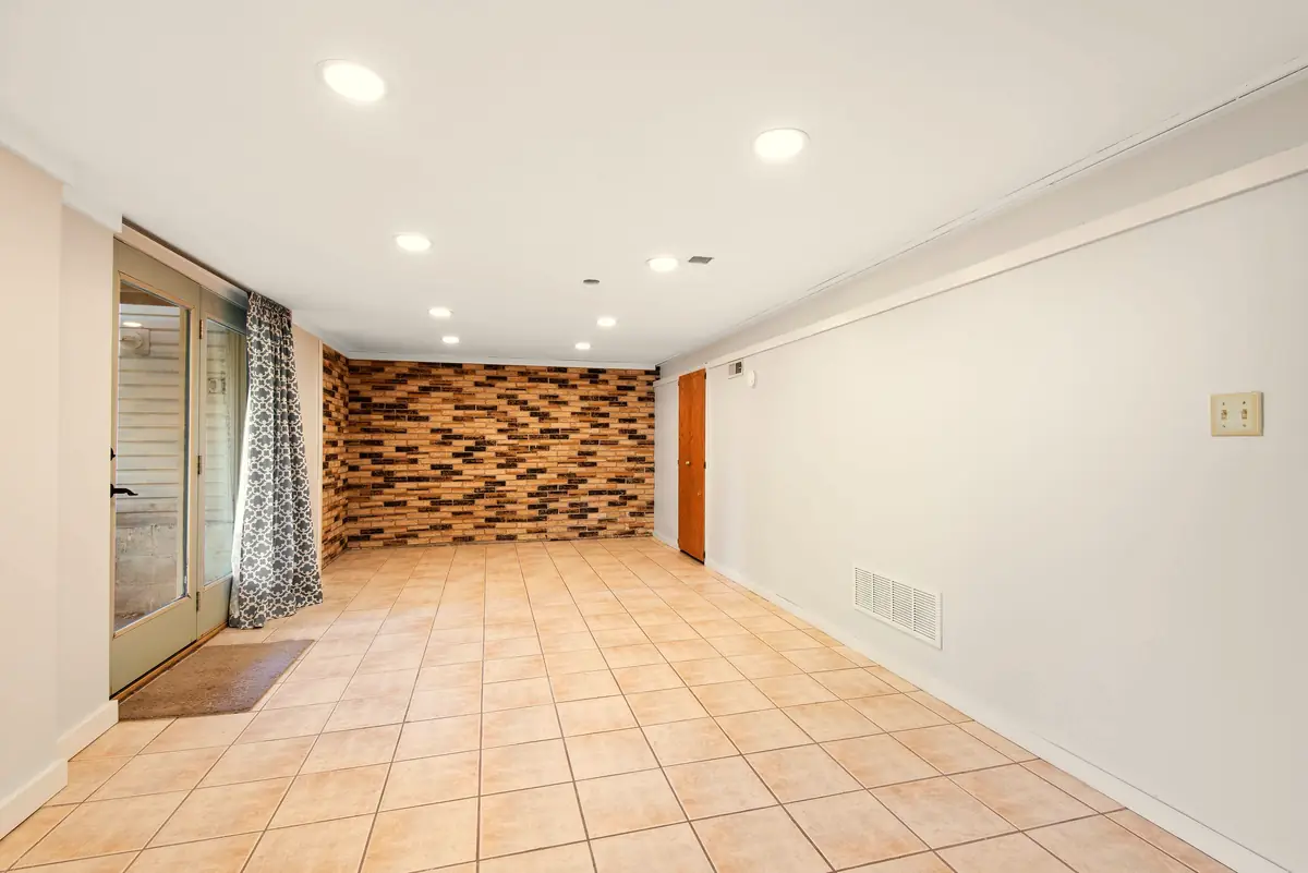 Bright basement with a brick accent wall and tile floor