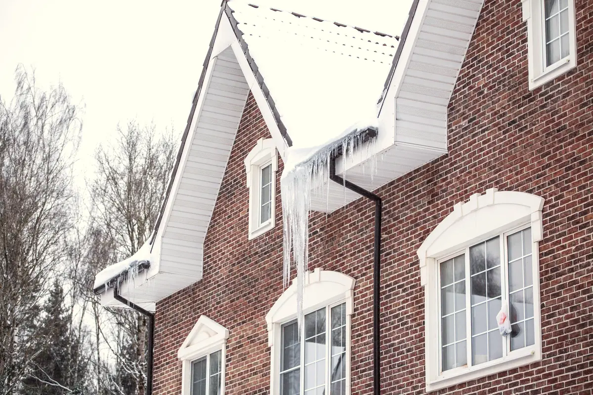 Icicles hanging from the eaves of a brick house after a hard freeze