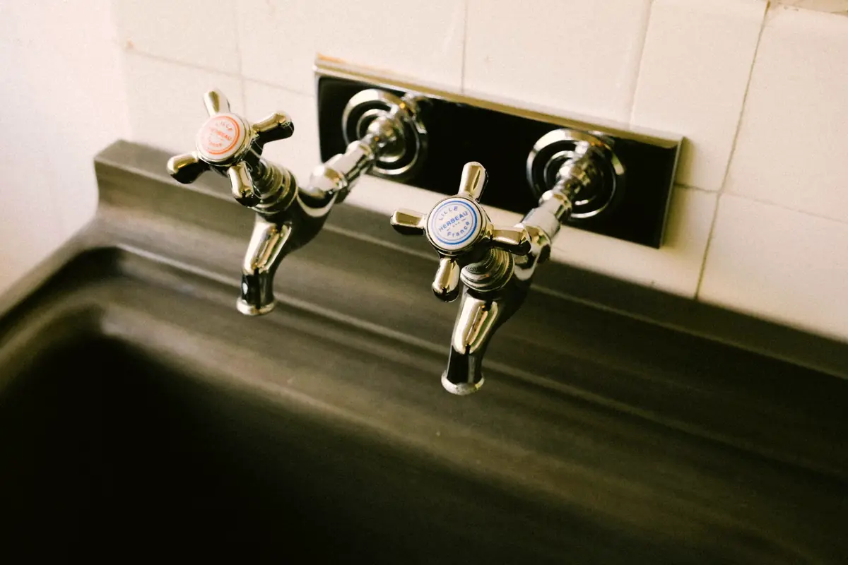 Chrome hot and cold kitchen taps over a sink