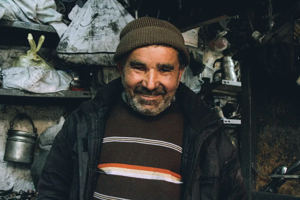 Smiling older man in a knit cap in his workshop