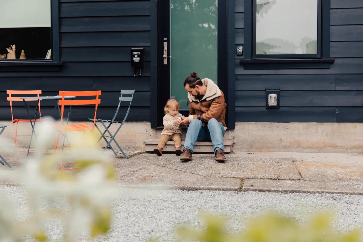 Father and child sitting on their front steps on a summer day