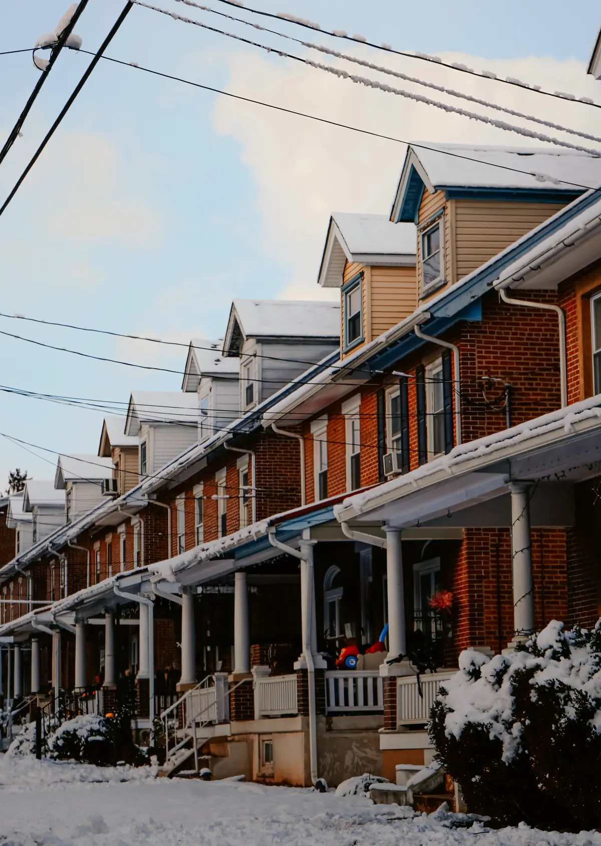 Row of porched brick houses after a snowfall