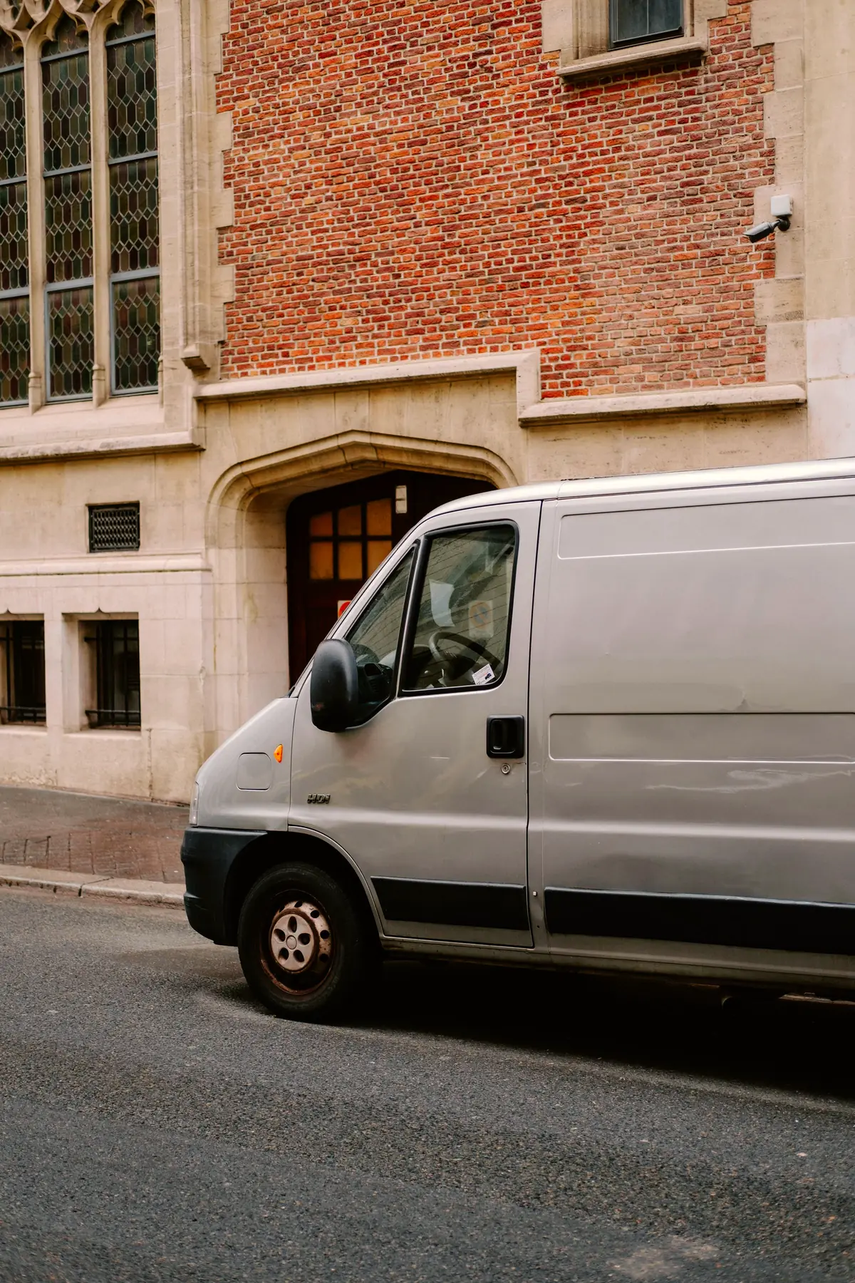 White service van parked beside an old brick building